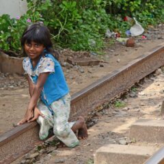 A girl sitting on the train tracks in Sri Lanka