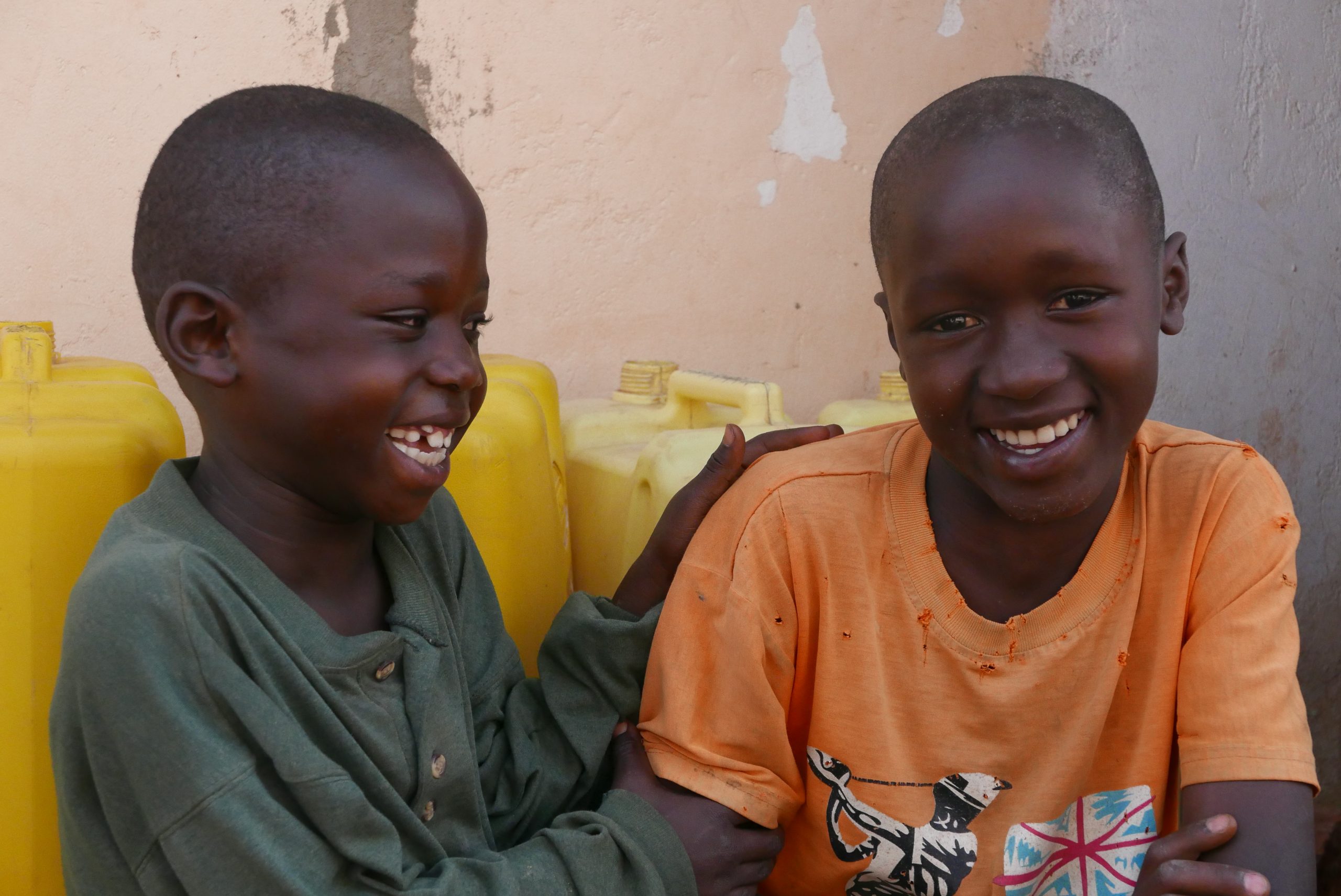 Two Ugandan children laughing together